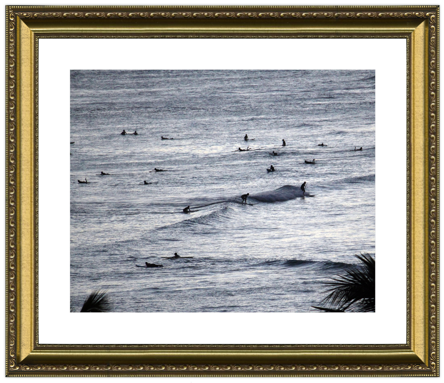 Framed artwork of a whale in the ocean with surfers, framed in gold.
