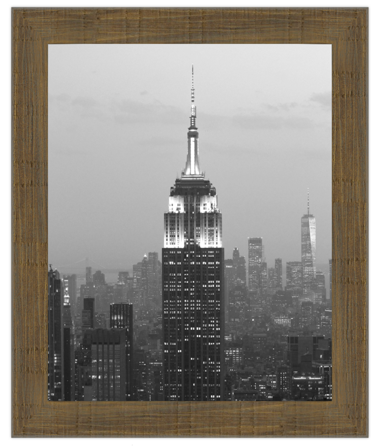 Framed artwork of a cityscape with a prominent building, likely the Empire State Building, at night.