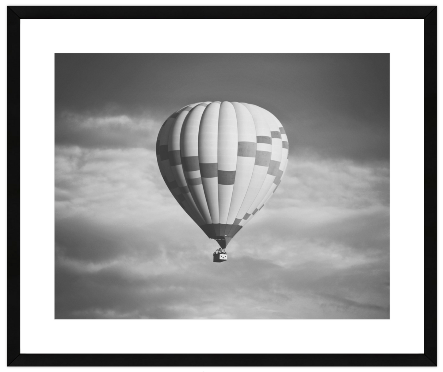 Hot air balloon in a cloudy sky, framed with a black border