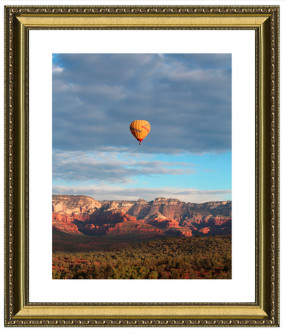 Hot air balloon over a desert landscape with a gold frame