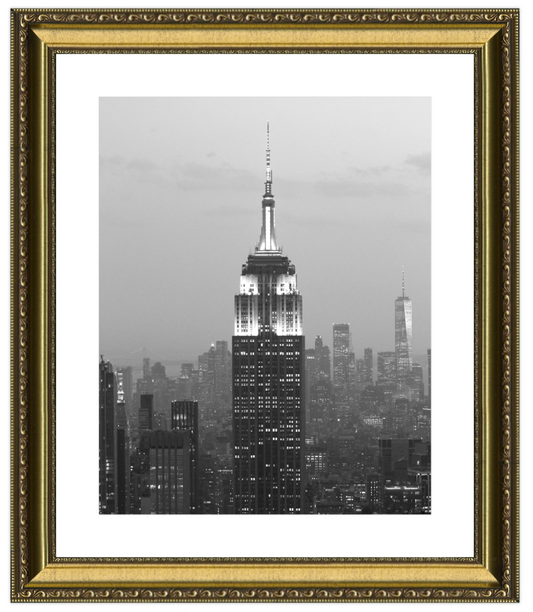 Framed black and white photo of a city skyline with a prominent building, likely the Empire State Building, at dusk.