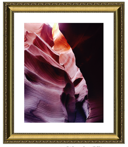 Framed photograph of a colorful canyon formation with a gold frame.