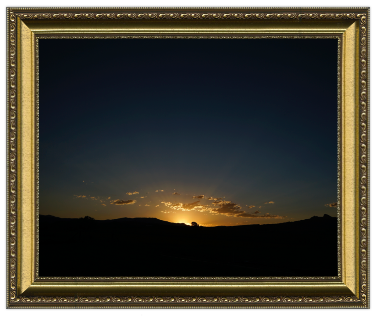Sunset over a landscape with a decorative gold frame.