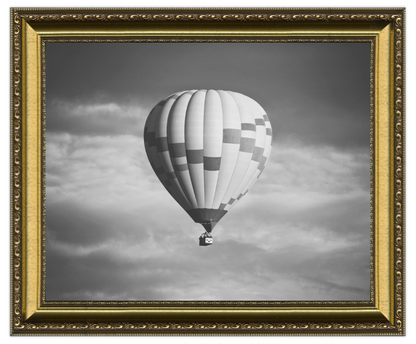 Hot air balloon in a cloudy sky with a gold ornate frame.