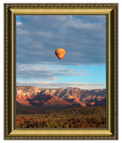 Hot air balloon over a desert landscape with a gold frame.