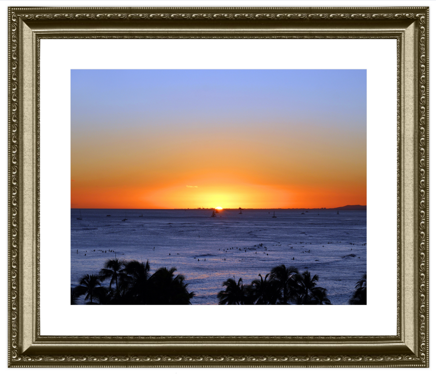 Framed artwork of a sunset over the ocean with palm trees.