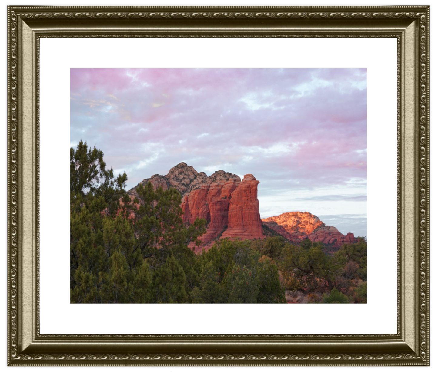 Framed photograph of a desert landscape with red rock formations and green trees.