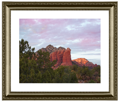 Framed photograph of a desert landscape with red rock formations and green trees.