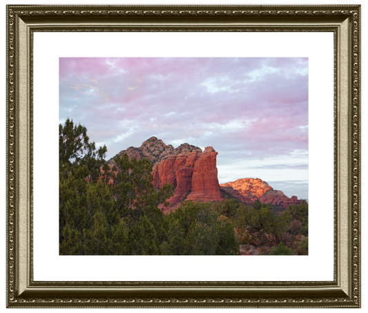 Framed photograph of a desert landscape with red rock formations and green trees.