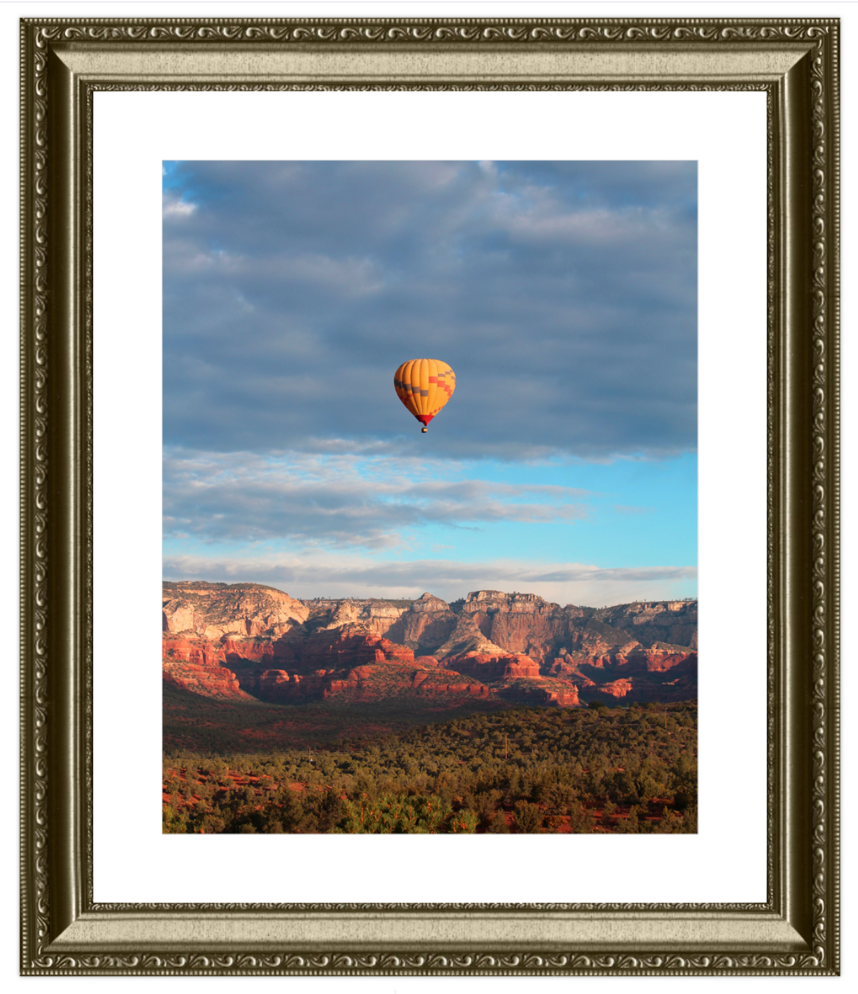 Hot air balloon over a desert landscape with a framed border