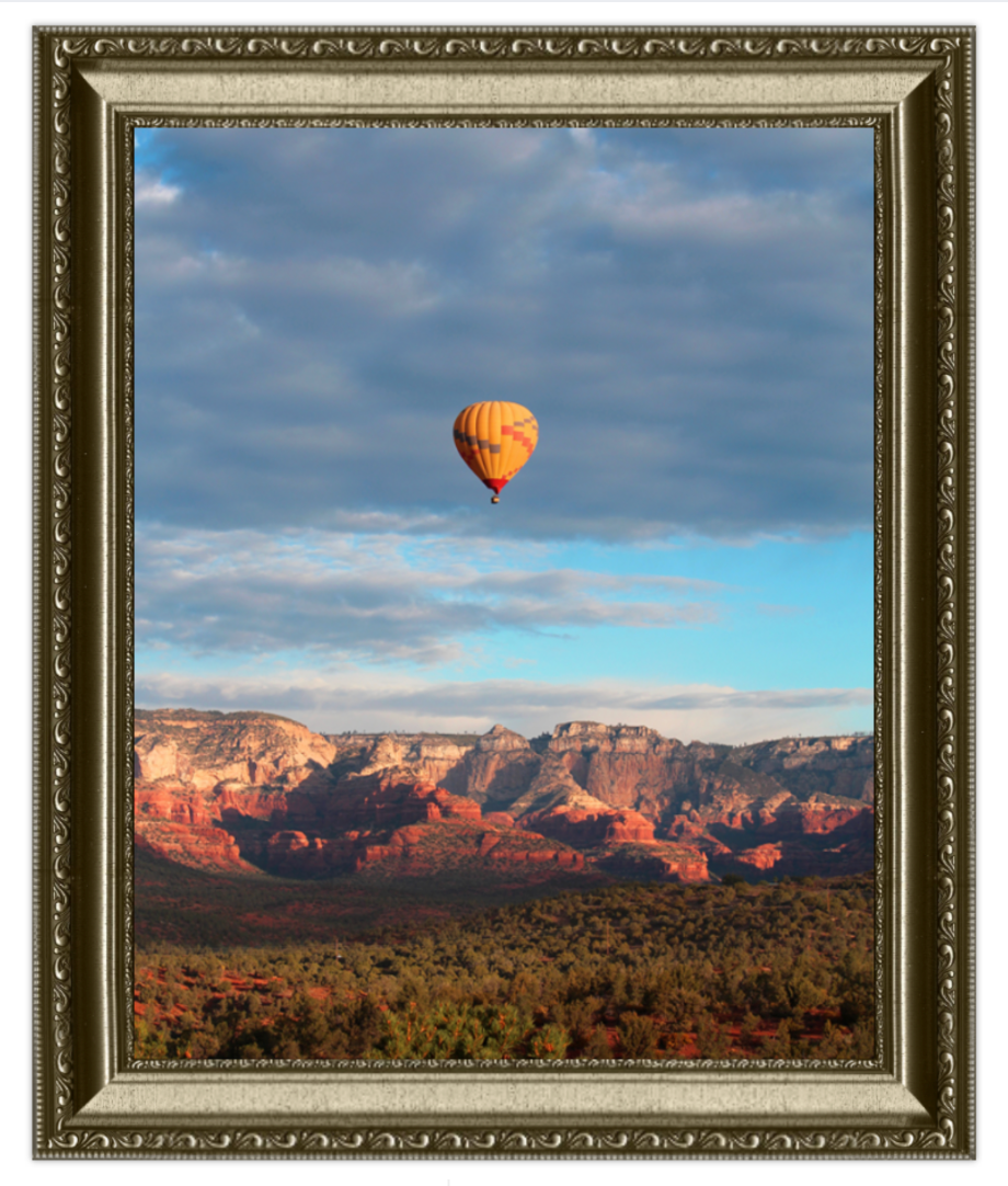 Hot air balloon over a canyon landscape with a decorative frame.