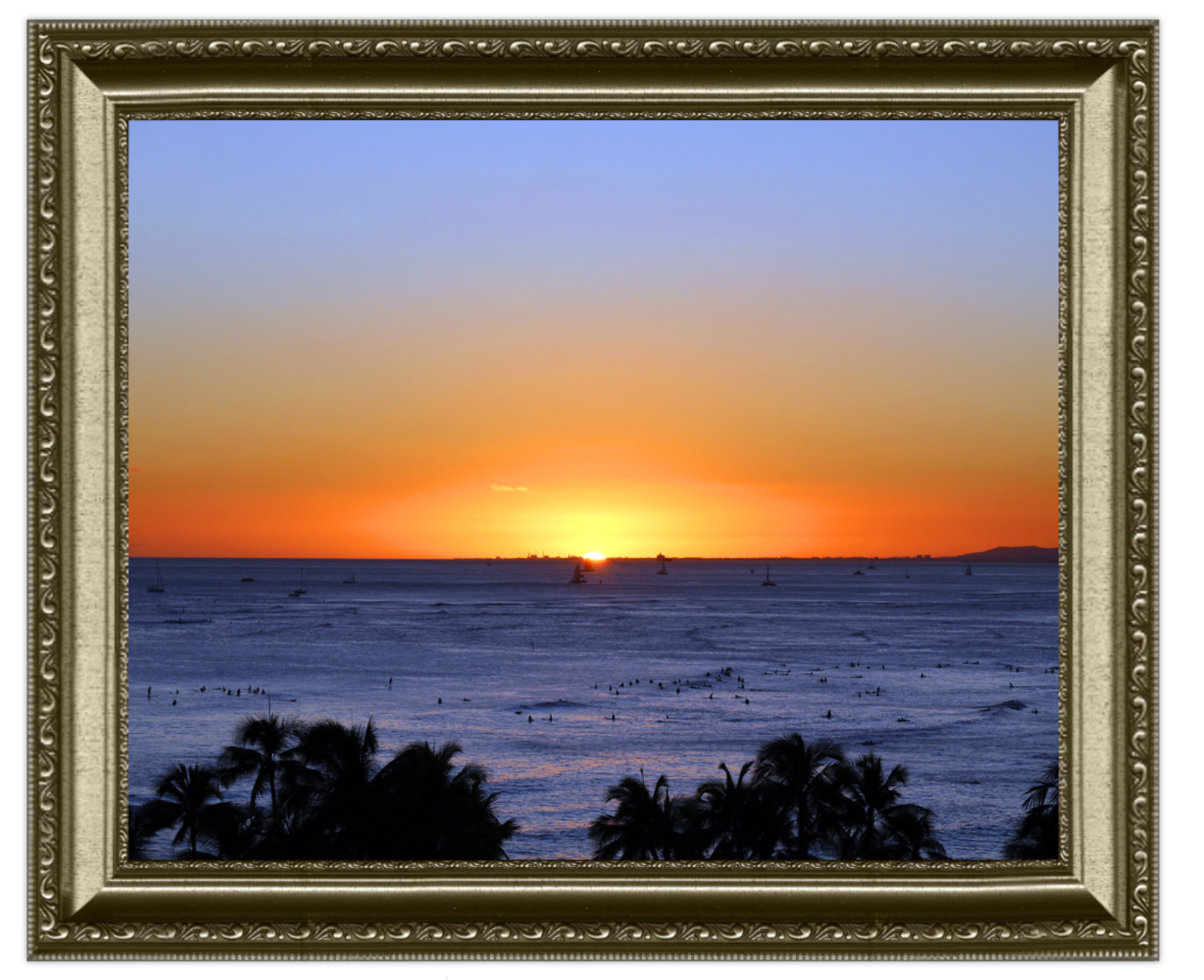 Sunset over the ocean with palm trees in the foreground
