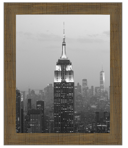 Framed artwork of a cityscape with a prominent building, likely the Empire State Building, at night.
