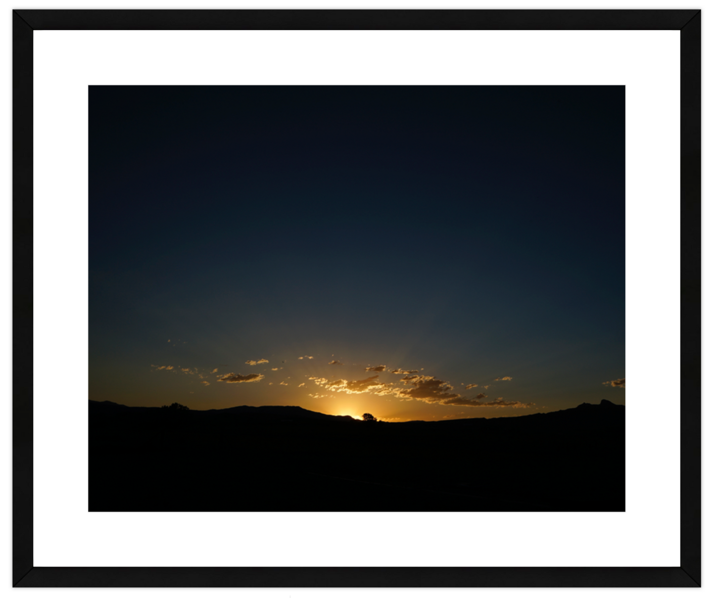 Sunset or sunrise over a landscape with a white border