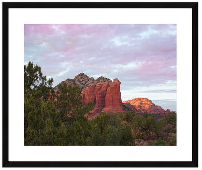 Scenic view of red rock formations with trees and a cloudy sky