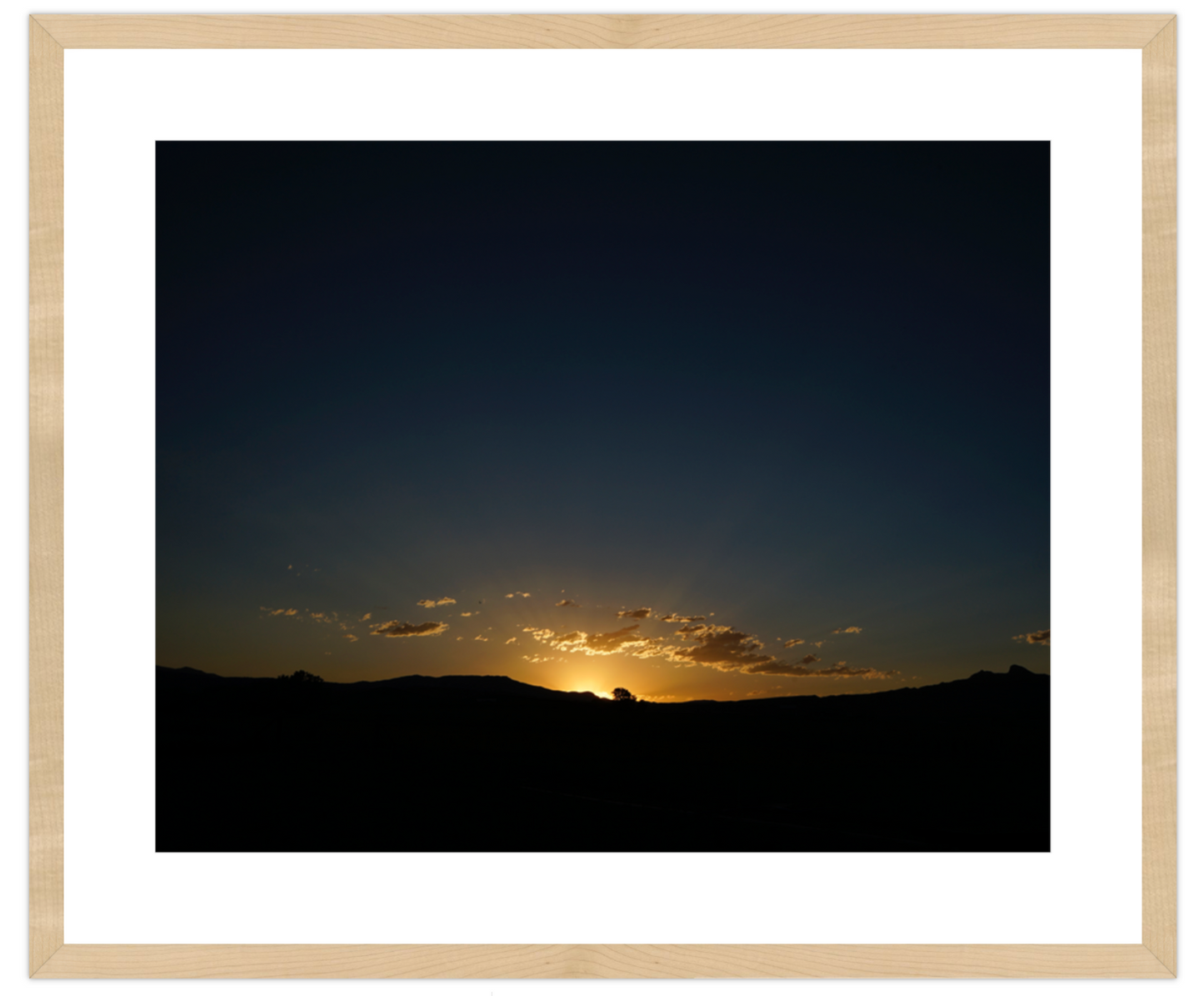Sunset over a mountain range with a wooden frame
