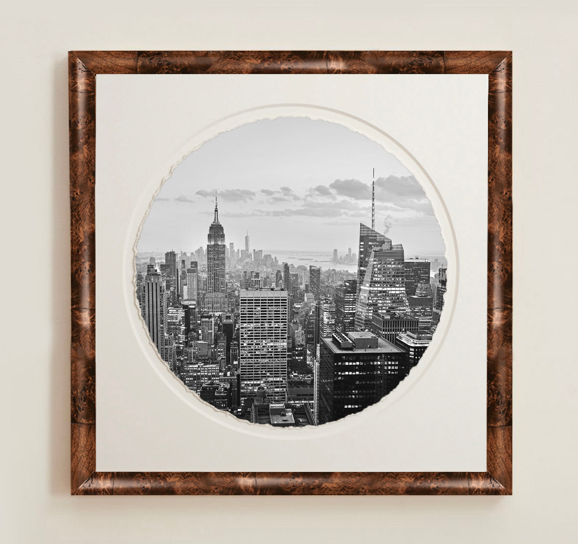 Framed black and white cityscape print on a plain wall.A collection of framed artwork prints with a deckled edge appearance, displayed in two museum style frames named Light Burlwood and Dark Burlwood. The frames are pictured in various sizes with a white mat and clear acrylic front.