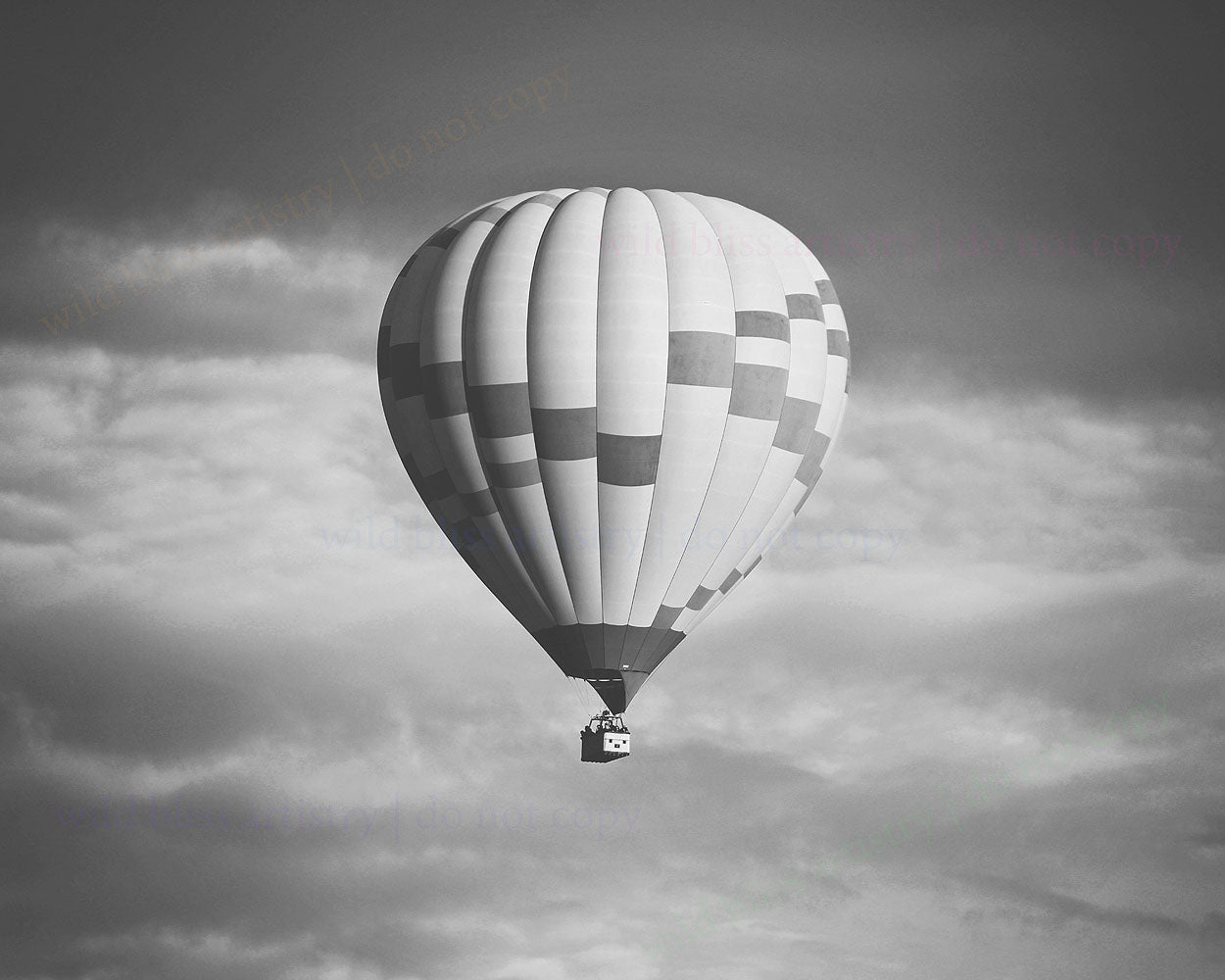 black and white image of large hot air balloon with clouds